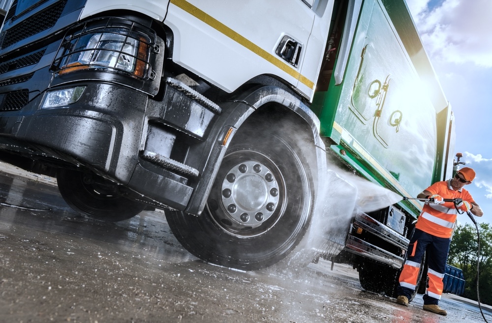 Transport and fleet employee washing a large truck